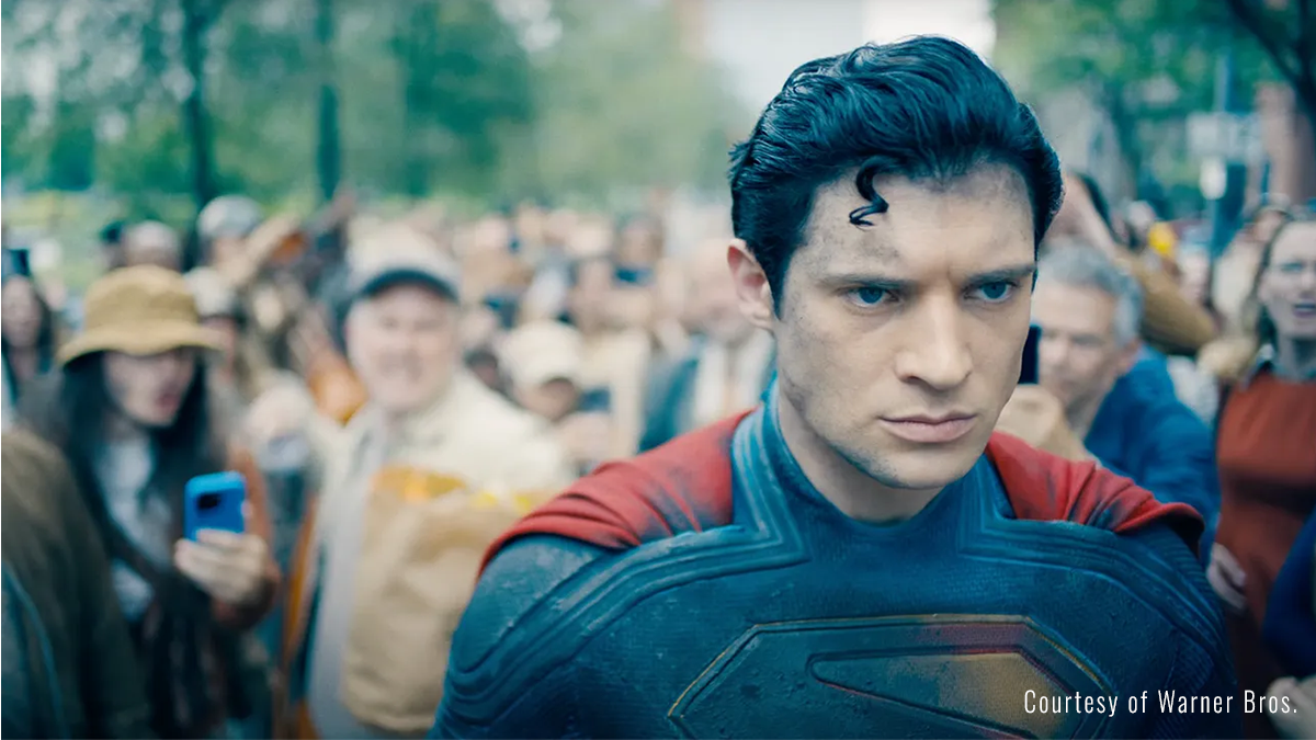 Superman walks through a crowd.